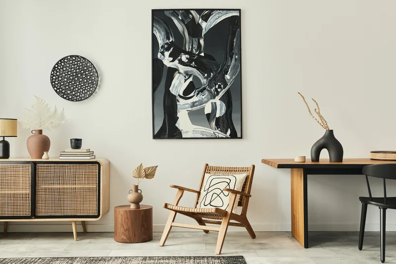 Minimalist living room with neutral walls, wooden chair, and black art. Minimalist living room with neutral walls, wooden chair, and black art.